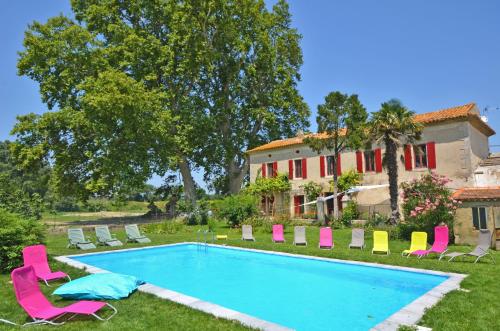 une piscine avec des chaises et une maison dans l'établissement Mas du Fer à Cheval, à Lamotte-du-Rhône