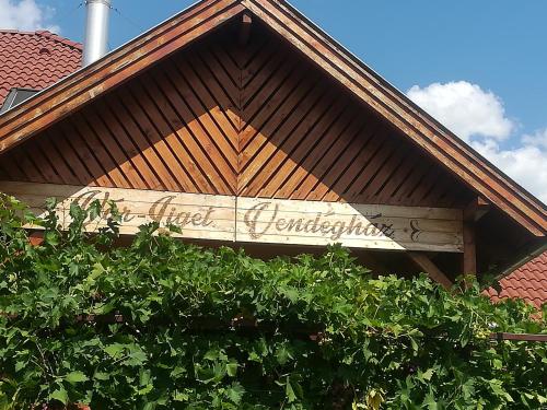 a sign on the roof of a building at Vár-Liget Vendégház in Kisnána
