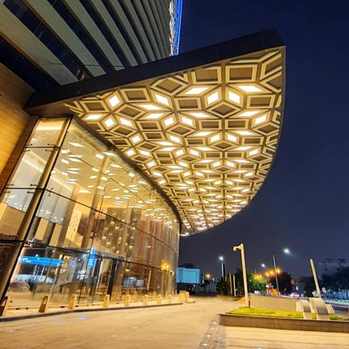 a building with a lit up facade at night at The Bentley Luxury Hotel & Suites in Doha