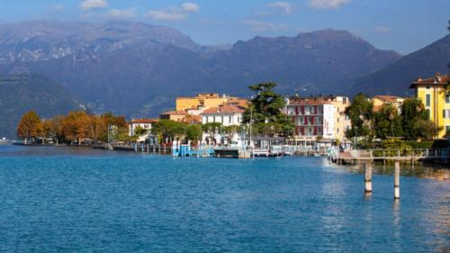 a large body of water with buildings and mountains at Appartamento seminterrato Villa Sveva Franciacorta in Ome