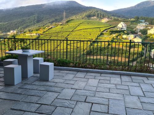 patio con mesa y vistas a la montaña en Villa Spring Acre, en Nuwara Eliya