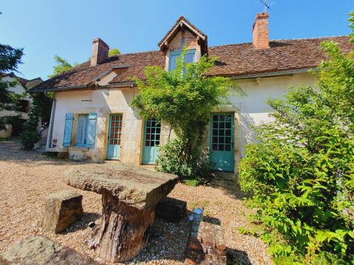 uma casa com um toco de árvore em frente em Ferme équestre & Chambres d'hôtes Gateau Stables proche Guédelon em Saint-Amand-en-Puisaye