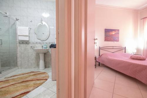 een badkamer met een bed, een douche en een wastafel bij Vila Elion Myloi in Symi