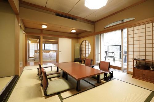a dining room with a table and chairs at Oku Yugawara SANSUIROU in Yugawara