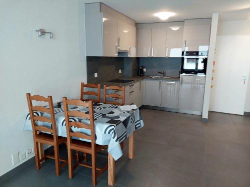 a kitchen with a table and chairs in a room at Haus Fortuna in Leukerbad