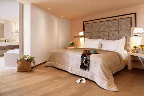 a bedroom with a large bed with a large headboard at Hotel Eden Roc - The Leading Hotels of the World in Ascona