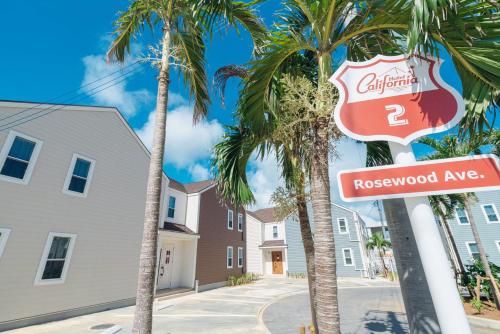 a street sign in front of palm trees at Hotel California Miyakojima Resort in Miyako Island