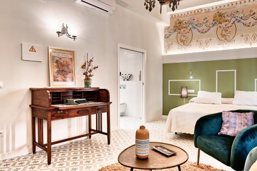um quarto com uma cama, uma secretária e um sofá em Blaucel Cafè i Habitacions em Cullera