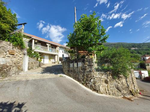 a house on the side of a stone wall at Castelo dos Sonhos in Valadares