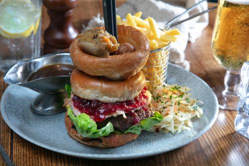 a plate with a sandwich with onion rings and fries at The Bold Hotel; BW Signature Collection in Southport