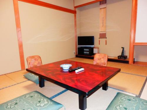 a living room with a wooden table and chairs at Nakayasu Ryokan in Kanazawa