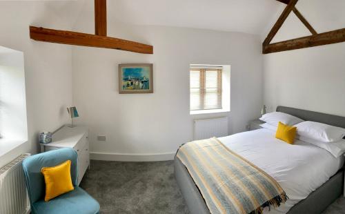 Bredwardine的住宿－The Retreat，一间卧室配有一张床和一张蓝色椅子