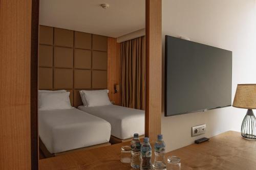 a hotel room with two beds and a flat screen tv at Amare Hotel in Shëngjin