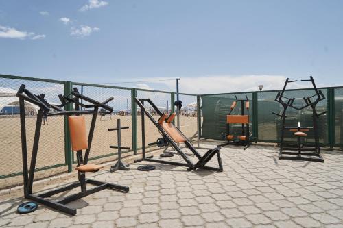 a group of exercise equipment next to the beach at Kapriz Issyk Kul Resort in Cholpon-Ata