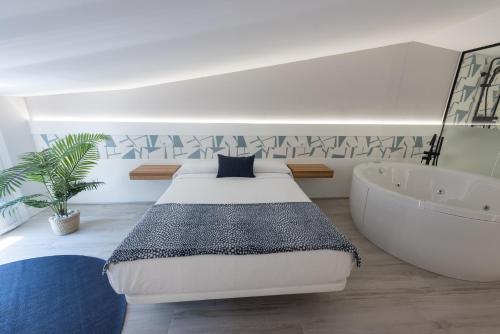 Schlafzimmer mit einem Bett und einer Badewanne in der Unterkunft APARTAMENTOS CUME DO PINDO in O Pindo