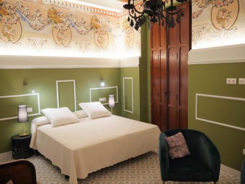 a bedroom with a white bed and a chair at Blaucel Cafè i Habitacions in Cullera