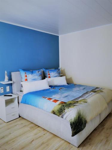 1 dormitorio con 1 cama grande y paredes azules en Gästehaus Anglerklause en Allstedt
