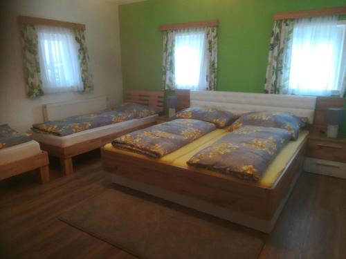 2 camas en una habitación con paredes y ventanas verdes en Ferienhaus Wuttijockl, en Oberhaag