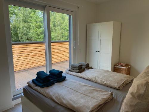 - 2 lits dans une chambre avec une grande fenêtre dans l'établissement Wohnen am Südstrand - Ferienwohnung 2 2, à Wyk auf Föhr