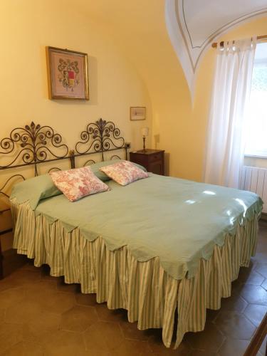 1 dormitorio con 1 cama con 2 almohadas en La Foresteria del Passeggere, en Ovada