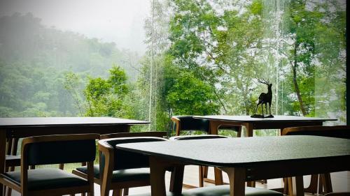 a room with tables and chairs and a window at 方圓行止 Funyuan Village in Puli