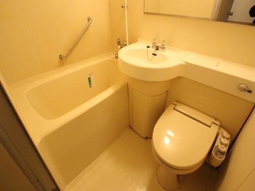 Baño pequeño con aseo y lavamanos en APA Hotel Komatsu en Komatsu