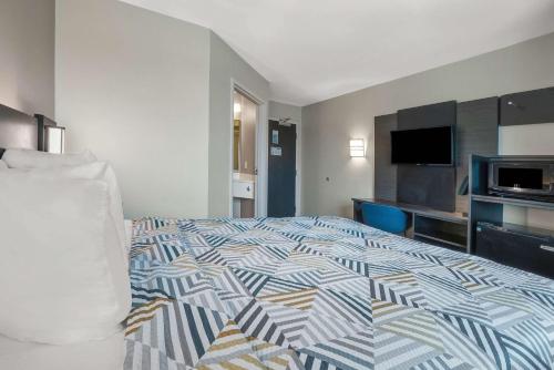 a hotel room with a bed and a flat screen tv at Motel 6-Montgomery, AL - Airport in Hope Hull