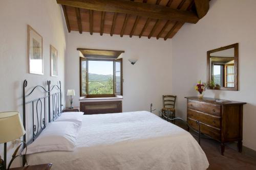 a bedroom with a large white bed and a window at Castello Di Meleto in Gaiole in Chianti