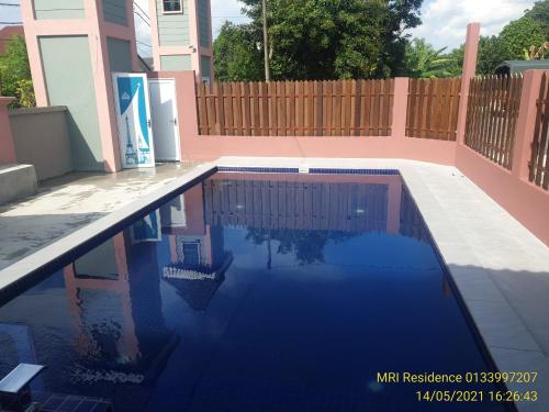 a swimming pool in front of a house at MRI Residence - Homestay in Sg Buloh with Swimming Pool - No Pork&Alcohol Allowed in Bandar Puncak Alam