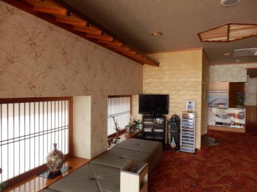 a living room with a couch and a flat screen tv at Hanagoyomi in Nanao