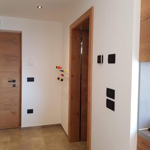 a hallway with a door and black squares on the wall at Rooftop-Schenna in Schenna