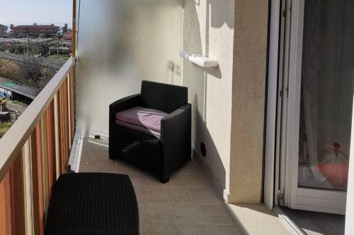 a black chair sitting on the side of a balcony at Appartamento - IRIS - Vallecrosia in Vallecrosia