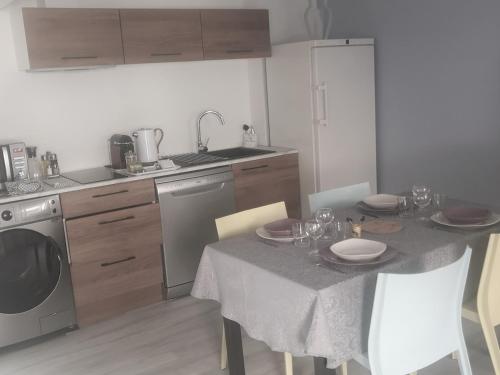 a kitchen with a table with plates and glasses on it at Centre ville historique - calme - les mots bleus in Besançon