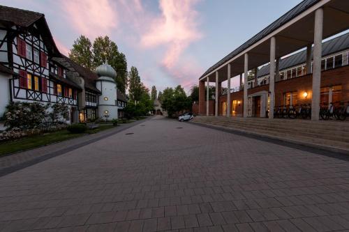 an empty street next to a building with a clock tower at See & Park Hotel Feldbach in Steckborn