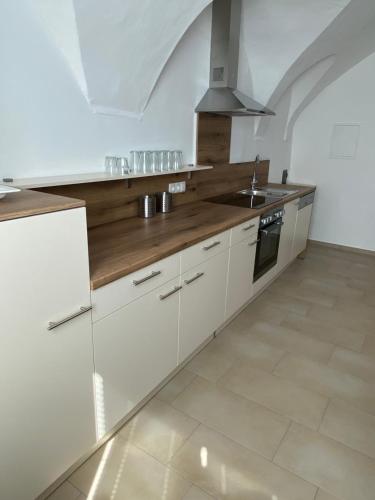 een keuken met witte kasten en een fornuis met oven bij Apart Felsenheimerhof in Nassereith