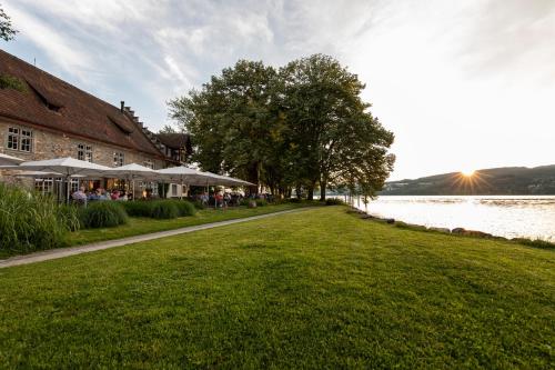 a path next to a building and a body of water at See & Park Hotel Feldbach in Steckborn