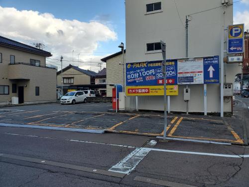 a parking lot next to a building with a parking meter at APA Hotel Komatsu Grand in Komatsu