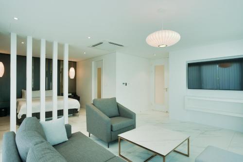 a living room with a couch and a tv and a bed at Villa de Aewol in Jeju