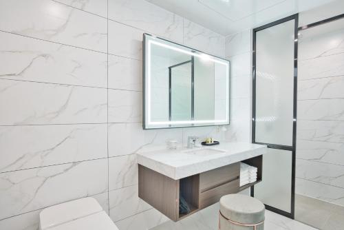 a white bathroom with a sink and a mirror at Villa de Aewol in Jeju