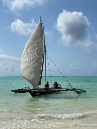 two people on a sail boat in the ocean at Cristal Resort in Paje