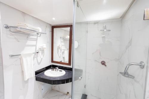 une salle de bain avec un lavabo et une douche dans l'établissement Hotel Majestic, à Casablanca