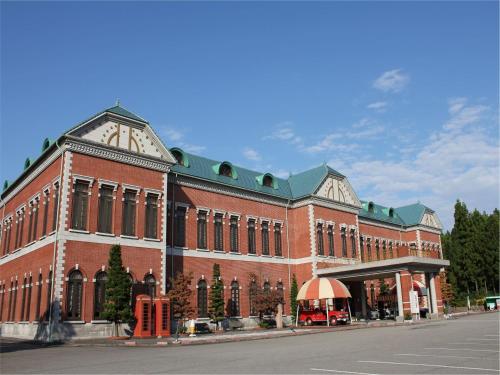 a large red brick building on a city street at APA Hotel Komatsu Grand in Komatsu