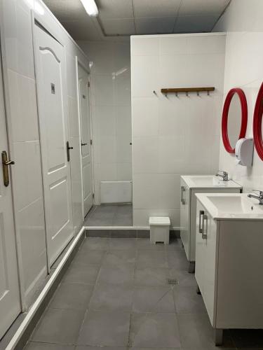 a bathroom with a toilet and two sinks and a door at Alberg Els Andes in Andorra la Vella