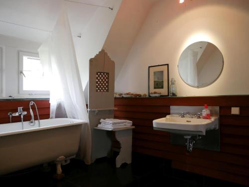 y baño con bañera, lavabo y espejo. en Villa Himmelsblau, en Bad Herrenalb
