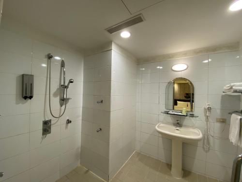 a bathroom with a shower and a sink and a mirror at 友愛金色商旅Golden Age Hotel in Taipei