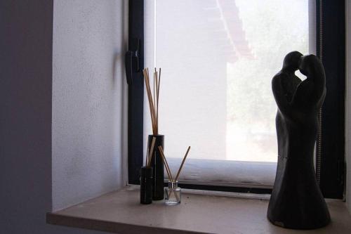 a window sill with a statue of two people at Private Villa with pool and magnificent view in Ceissa