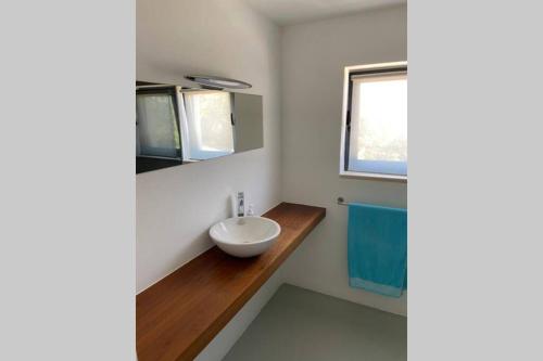 a bathroom with a white sink and a window at Private Villa with pool and magnificent view in Ceissa