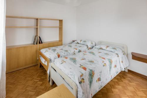 a bedroom with two beds and a wooden floor at Dimora Augusto & Valentina in Maiano