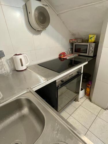 a small kitchen with a sink and a microwave at Alberg Els Andes in Andorra la Vella