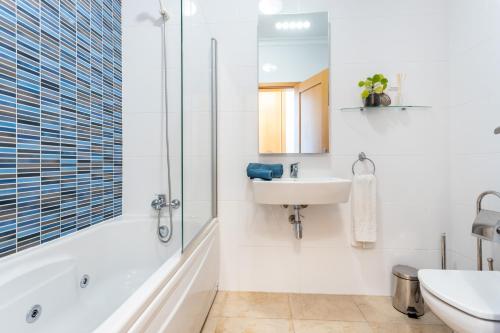 a bathroom with a tub and a sink and a shower at Casa Contente in Lagos